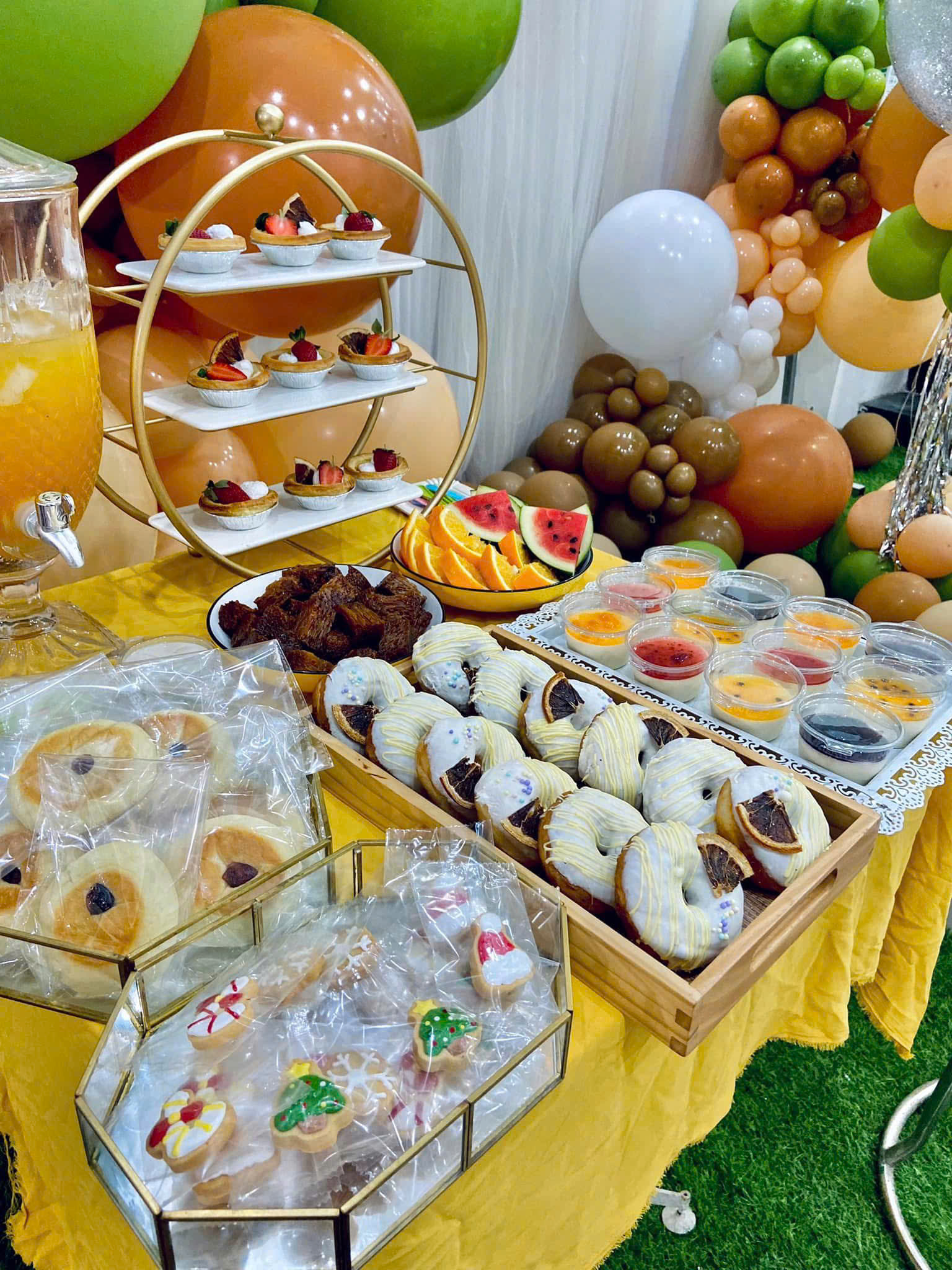 Bàn tiệc tea break tông vàng với bánh ngọt, trái cây và nước uống